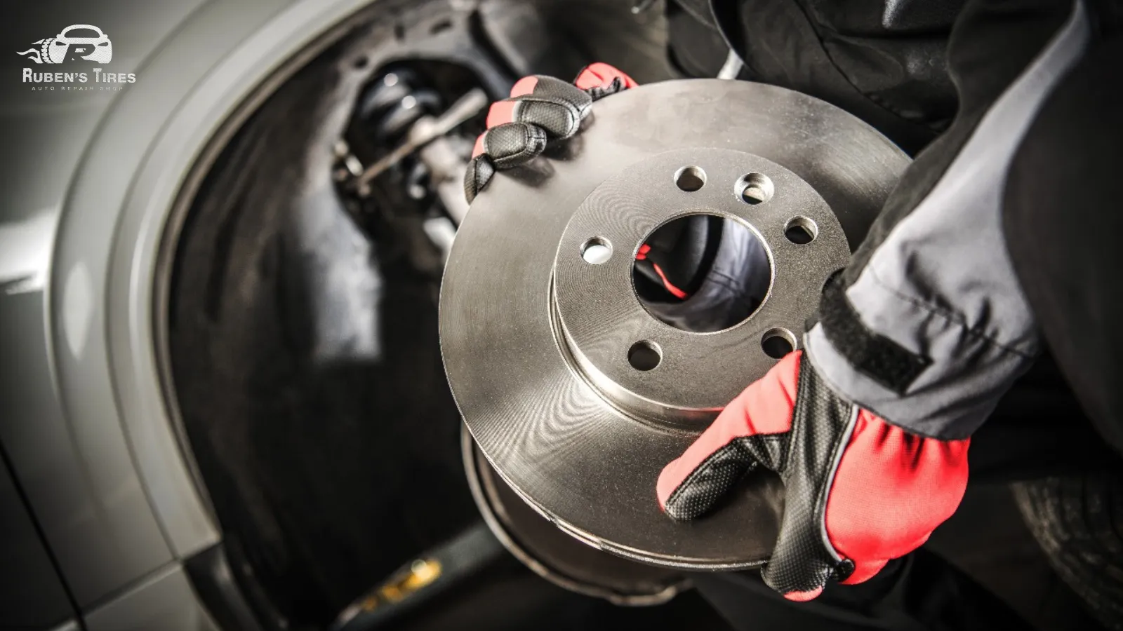 Mechanic holding a new brake rotor for installation in a vehicle.