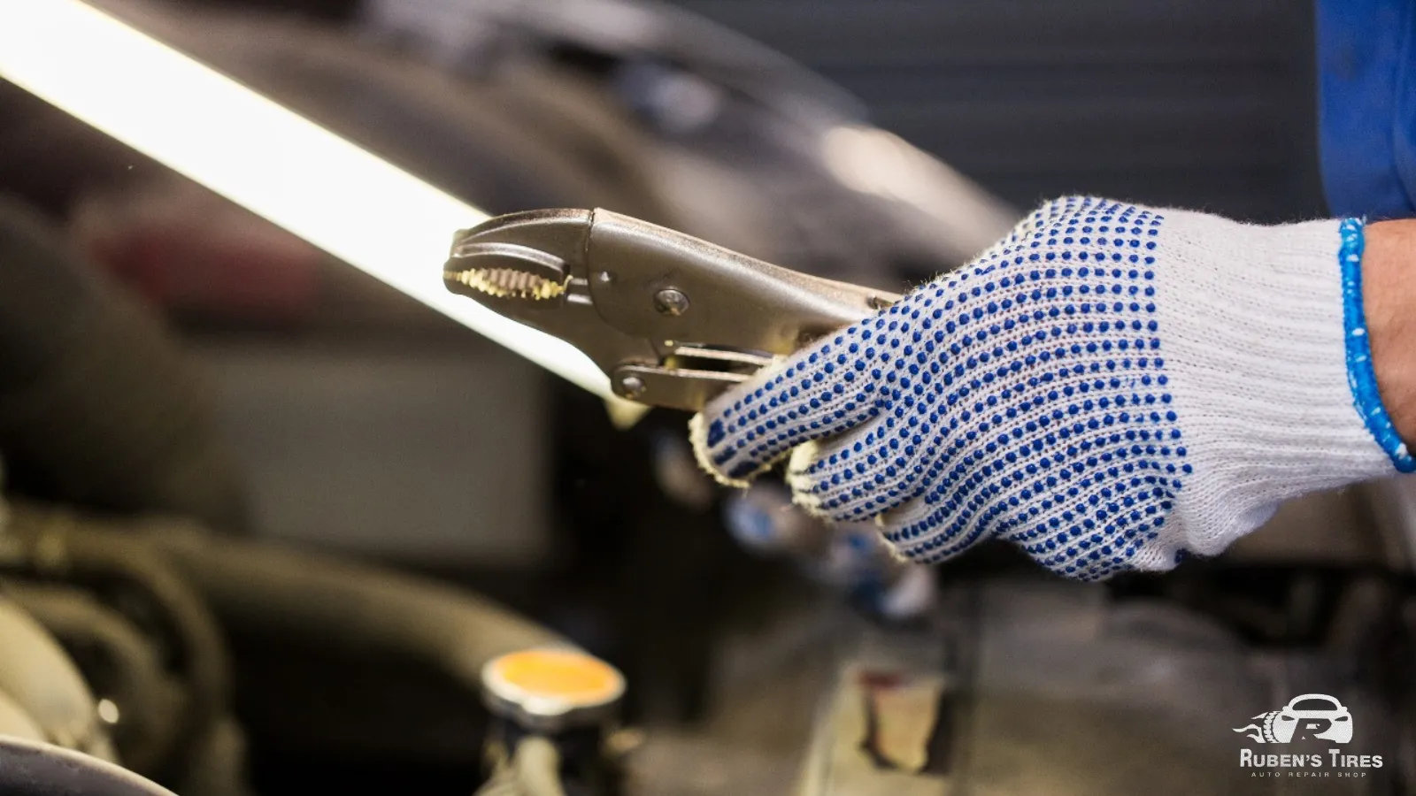 A mechanic using specialized tools for engine repairs at Ruben’s Tires in Altamonte.