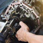 Technician’s hands working on intricate transmission components, demonstrating detailed Transmission Repair Altamonte Springs service at Ruben’s Tires.
