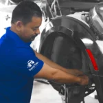 Ruben’s Tires technician performing detailed work on a vehicle's rear wheel assembly, delivering expert Brake Repair Altamonte Springs with precision and care.