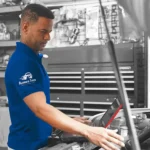 Technician reviewing diagnostics while performing service under the hood, showcasing the precision and care behind Ruben’s Tires Synthetic Oil Change Altamonte.